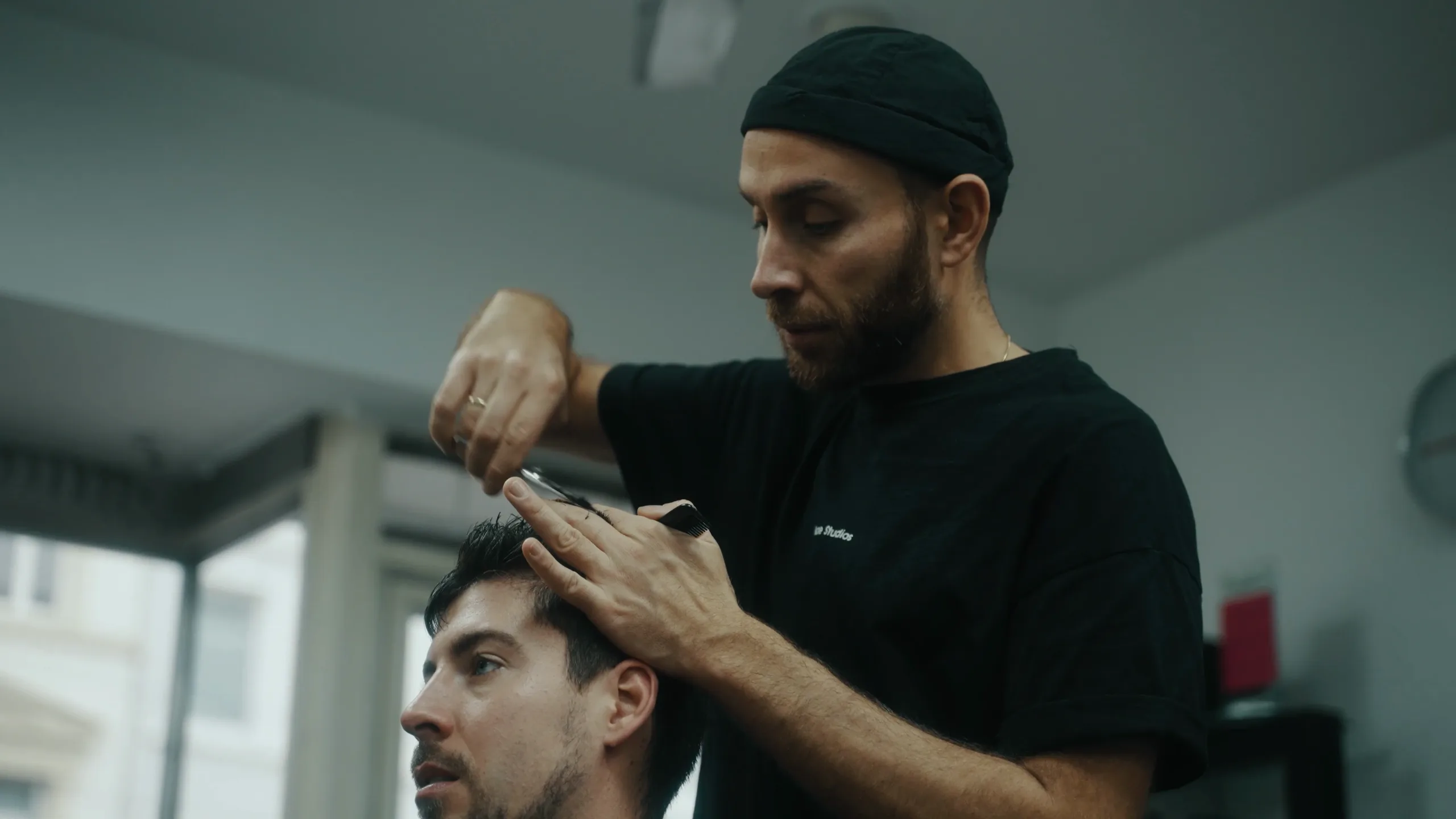 Ein Friseur schneidet einem Kunden die Haare.