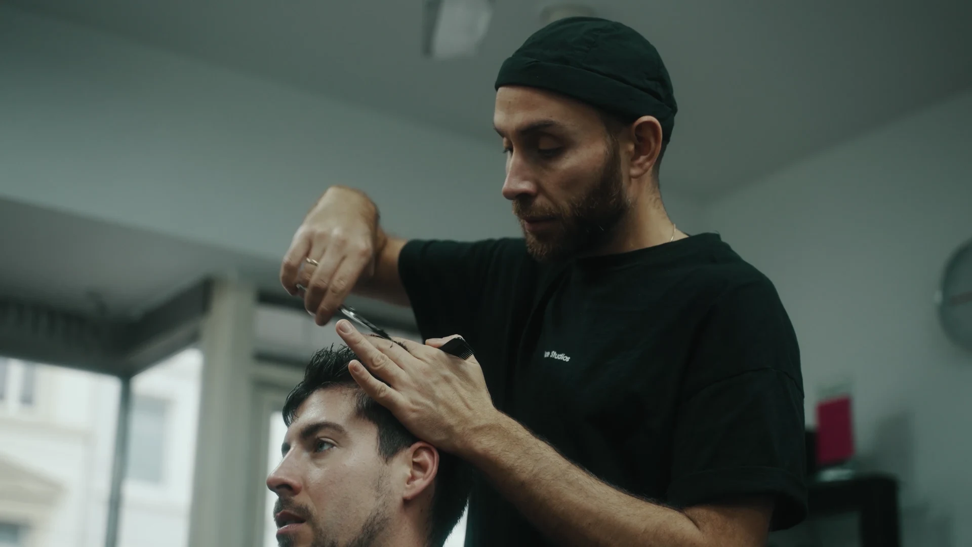 Ein Friseur schneidet einem Kunden die Haare.